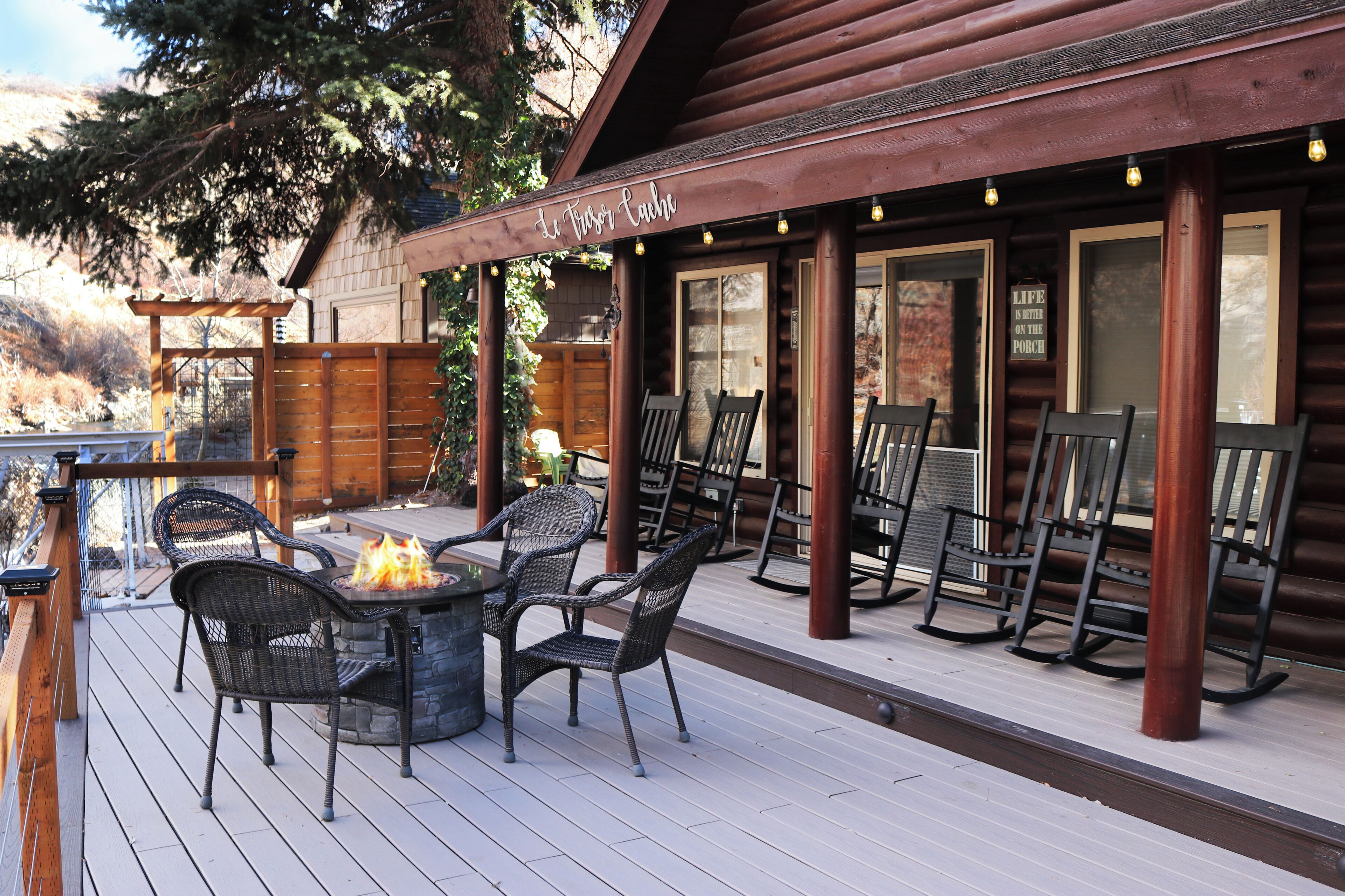 Eine Holzterrasse mit Sitzgelegenheit und einem Feuerkorb.