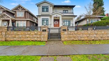 Ein zweistöckiges Haus mit einer Steinmauer und einem Eingangstor.