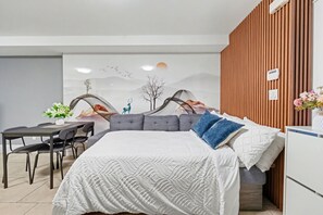 Une chambre à coucher moderne avec un lit, un bureau et une chaise.