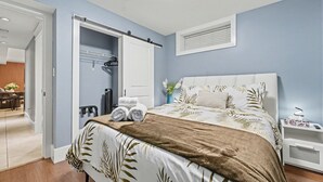 A bedroom with a bed, a wardrobe, a bedside table, and a window. - Quiant 2 Bedroom Suite by Mroke Vacations (Vancouver)