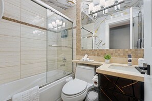 Une salle de bain moderne avec une douche à parois de verre, des toilettes et un lavabo avec un miroir au-dessus.