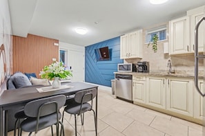 A modern kitchen with white cabinets, a microwave, and a dishwasher.