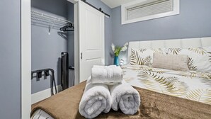 A bedroom with a bed, a towel on the bed, a window, and a door. - Quiant 2 Bedroom Suite by Mroke Vacations (Vancouver)