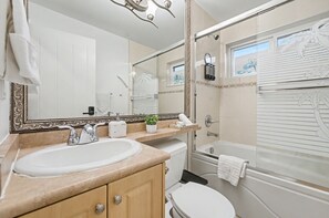 A bathroom with a large mirror, a sink, a toilet, and a shower area. - Secluded Bachelor Suite by Mroke Vacations (Vancouver)