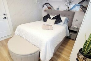 A bedroom with a bed, bedside table, and a potted plant. - Secluded Bachelor Suite by Mroke Vacations (Vancouver)