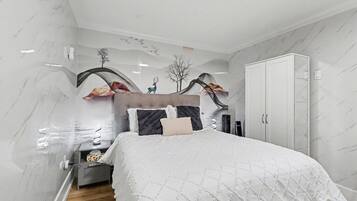 A bedroom with a bed, a wardrobe, and a nightstand.