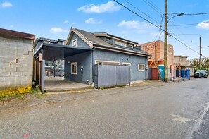A residential building with a garage, a covered entrance, and a visible staircase. - Cozy Laneway House Getaway by Mroke Vacations (Vancouver)