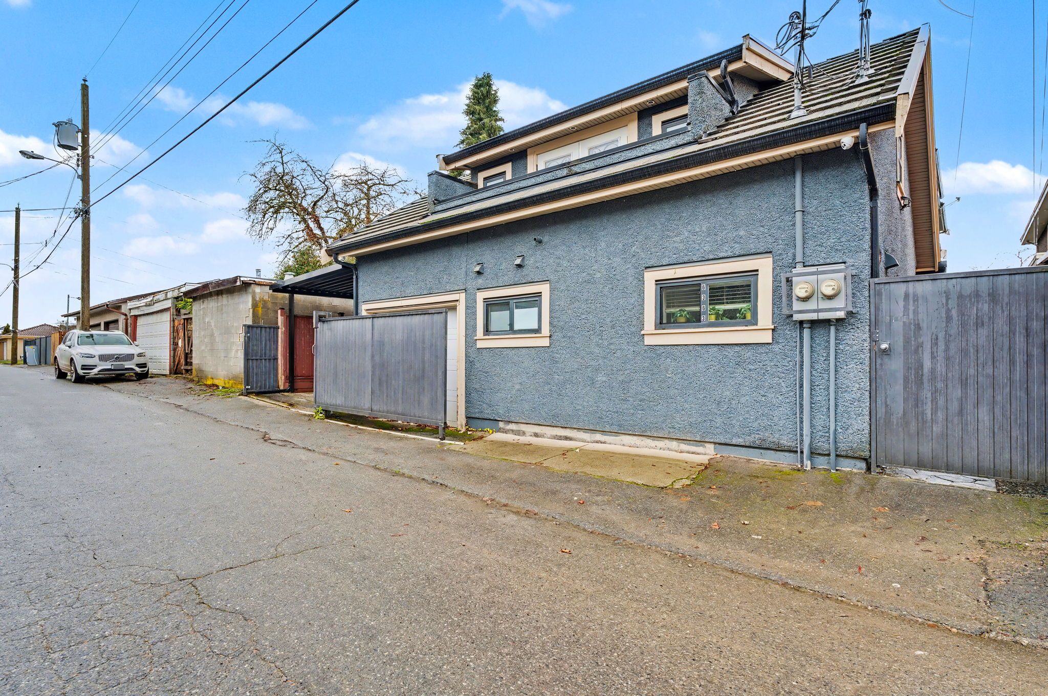 A residential building with a garage, a fenced yard, and a clear sky.