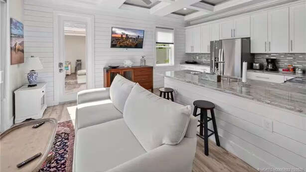 A modern kitchen with white cabinetry, a marble countertop, and stainless steel appliances. - Bring Boat! Heated Pool & Spa/Kayaks/Bikes/Fishing (Stuart)