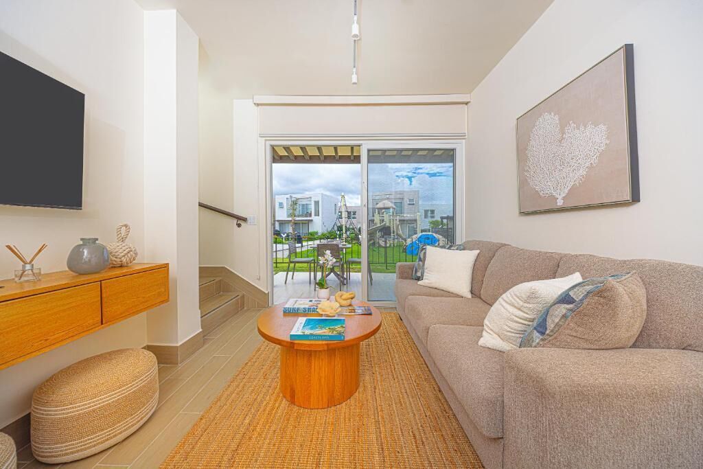 A modern living room with a sofa, coffee table, and artwork.