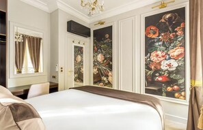 Ein Hotelzimmer mit einem großen Bett, einem Schreibtisch und einem Kleiderschrank.