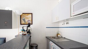 A compact kitchen with a coffee machine, a sink, and a microwave. - "Le Pajo" Seafront apartment, T3 Air-conditioned - Wifi, Swimming pool and parking lot (Sète)
