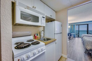 A compact kitchen with a stove, microwave, and refrigerator. - New Direct Ocean View 12th Floor, Sandcastle South (Myrtle Beach)