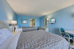 A hotel room with a large bed, a desk, a chair, and a TV mounted on the wall. - New Direct Ocean View 12th Floor, Sandcastle South (Myrtle Beach)