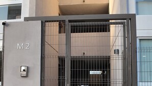 Modernilla tyylillä suunnitellun rakennuksen portti, jossa on metallinen portti ja numerokoodilukko.