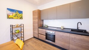A modern kitchen with wooden cabinets, a black countertop, and a stainless steel oven. - Villa Manù - Sicilian Charm Retreat (Sicilia)