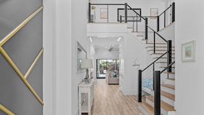 Ein modernes Interieur mit Treppe, Flur und Wohnbereich.