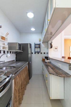 A modern kitchen with a stainless steel refrigerator, a microwave, and a sink. - Charm in Copacabana Stc1002 (Rio de Janeiro)