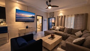 A modern living room with a flat-screen TV, a ceiling fan, a sofa set, and a coffee table. - Pyramid Tranquility/Luxury Retreat in Ocho Rios, St. Ann (Ocho rios)