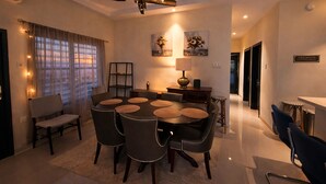 A dining area with a round table, chairs, a ceiling fan, and a lamp. - Pyramid Tranquility/Luxury Retreat in Ocho Rios, St. Ann (Ocho rios)