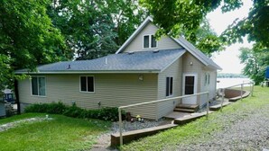 Ein eingeschossiges Haus mit Veranda, kleiner Terrasse und Kiesweg.