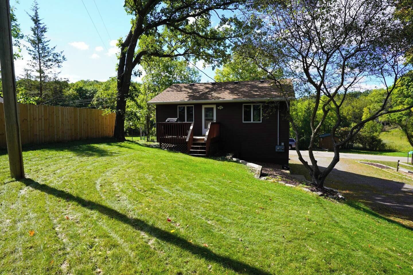 Ein kleines Haus mit Veranda und einem eingezäunten Garten.