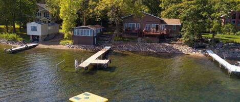 A lakeside property with a dock, a small boat, and a floating platform.