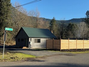 Une petite cabane en bois avec un toit vert, située à l’intersection de la rue Haynes Avenue North et d’une autre route.