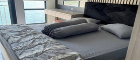 Une chambre moderne avec un grand lit, une table de chevet et une vue sur la mer.