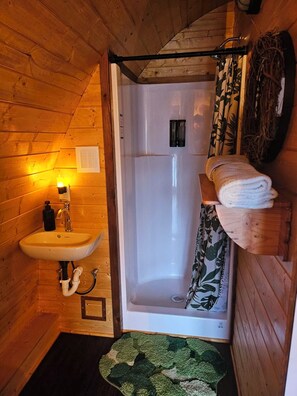 Chuveiro, toalhas de banho, sabonete, papel higiênico