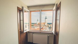 A corner room with a large window overlooking a cityscape with prominent towers. - Gold Hotel Zlotoryja (Zlotoryja)