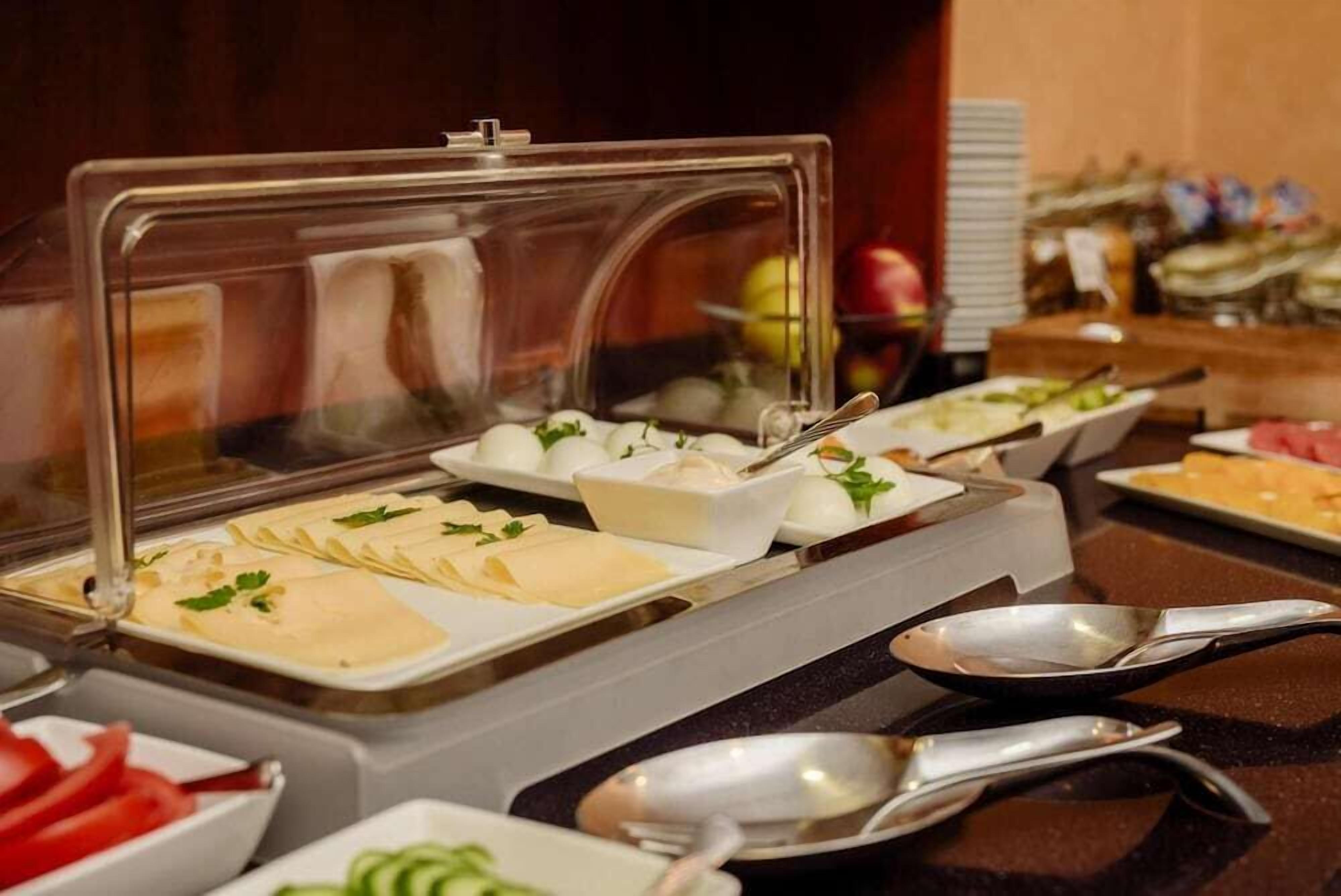 Un buffet proposant une variété de plats et d’ustensiles de service.
