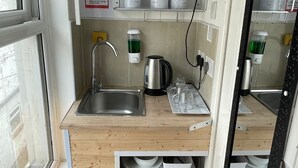 Uma cozinha compacta com micro-ondas, pia e armários.