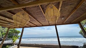 A beachside structure with a thatched roof and two hanging wicker lamps. - La Perla @ Rocamar (Jicalapa)