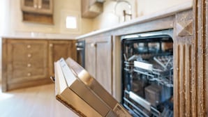 Una cocina con armarios de madera, lavavajillas y horno empotrado.