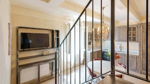 Una cocina moderna con un televisor grande, una mesa de comedor y una araña.