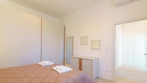 A bedroom with a large bed, a bedside table, a mirror, and a wardrobe. - Cignani Loft (Bologna)