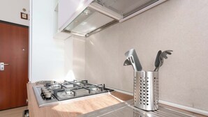 A modern kitchen with a stainless steel stove, a wooden countertop, and a stainless steel utensil holder. - Cignani Loft (Bologna)
