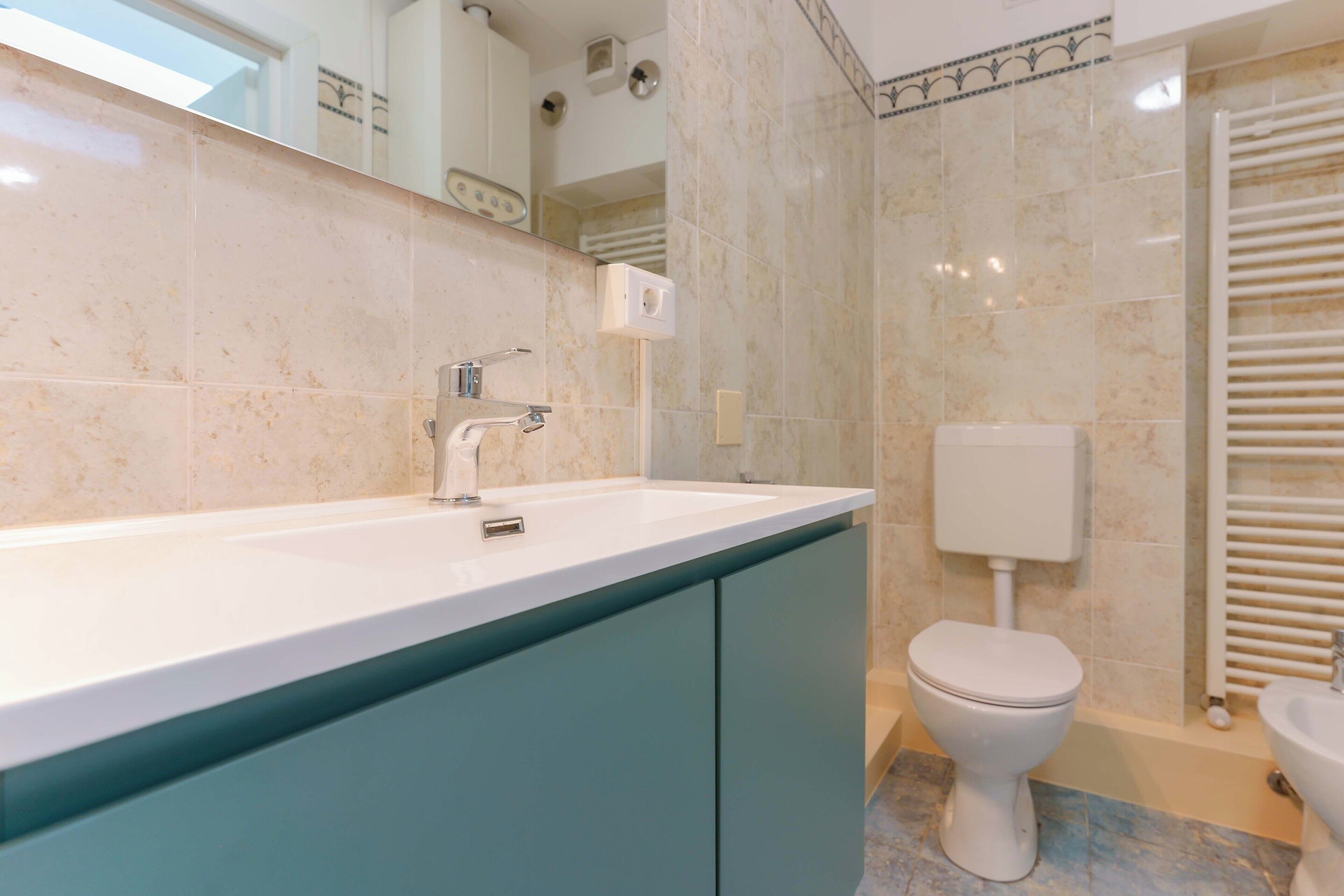 A bathroom with a white sink, a toilet, and a shower area.
