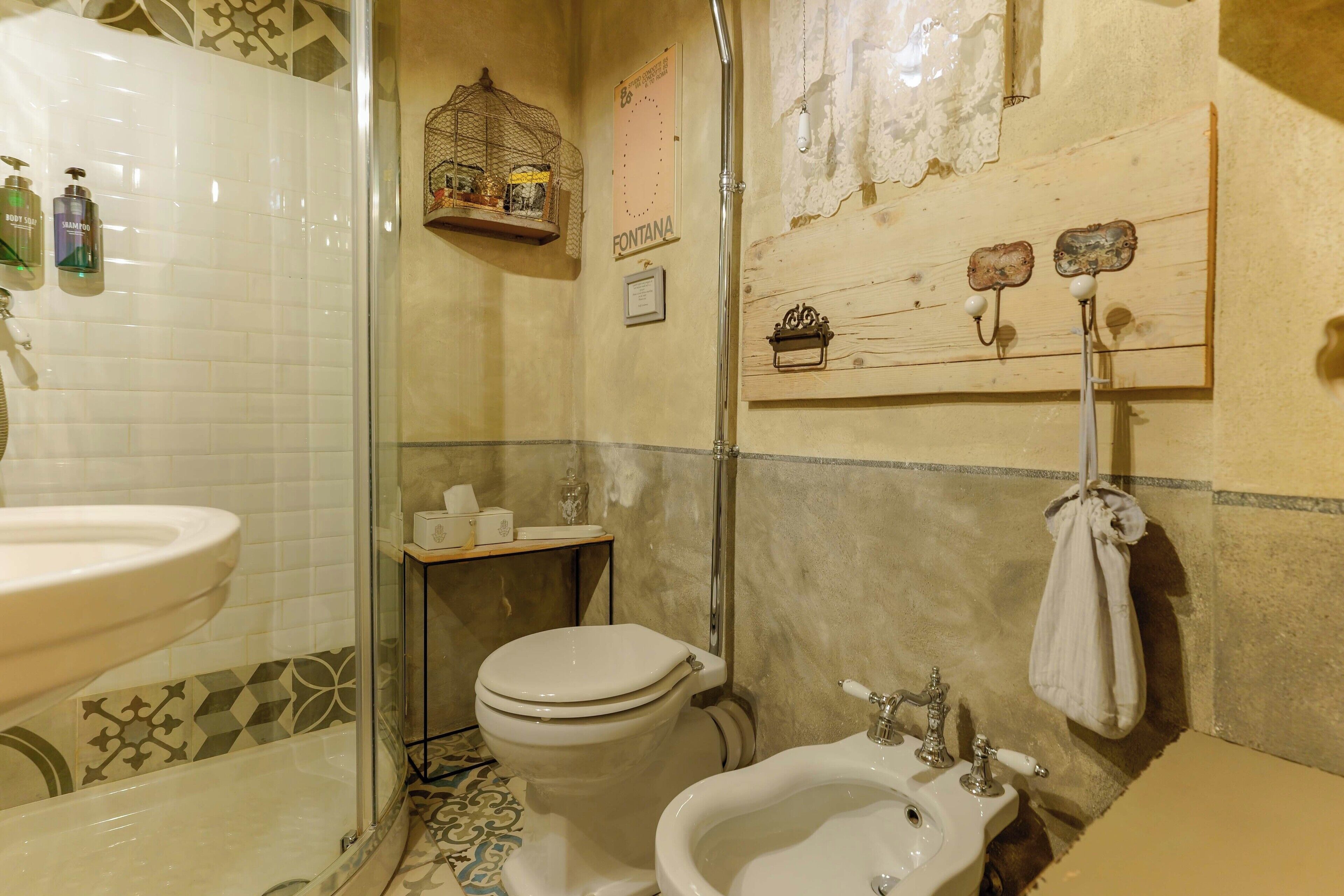 Ein Badezimmer mit Toilette, Bidet, Waschbecken und Dusche.