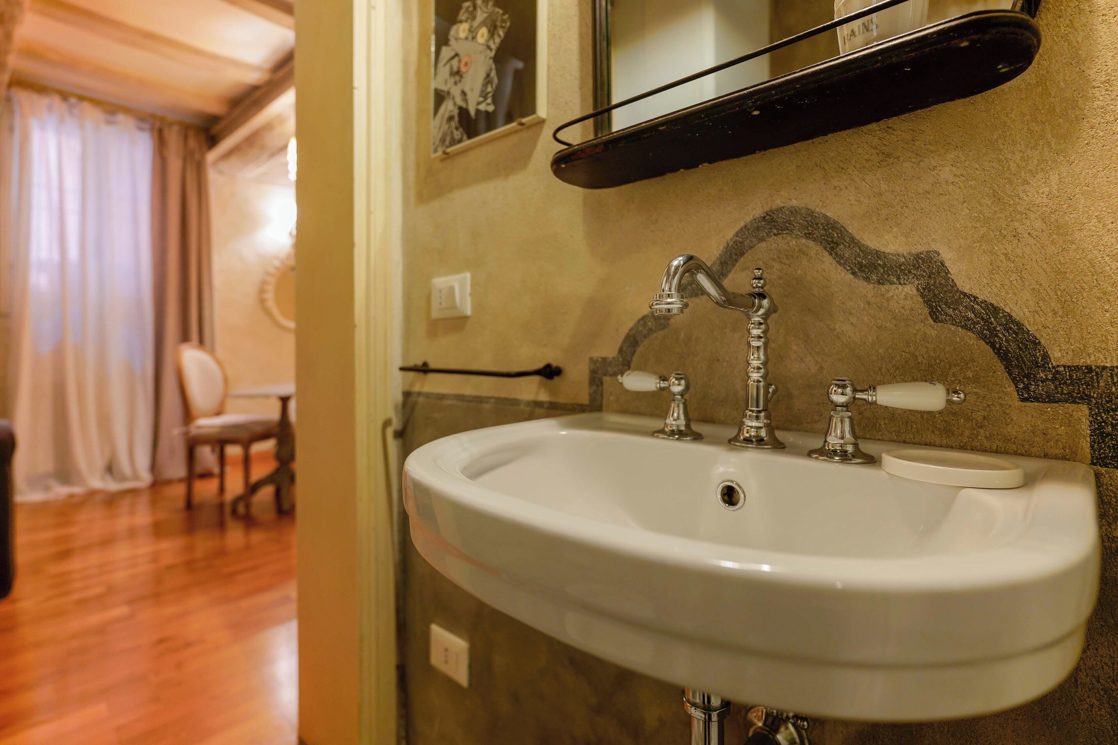 A bathroom with a white sink, two faucets, and a mirror above it.