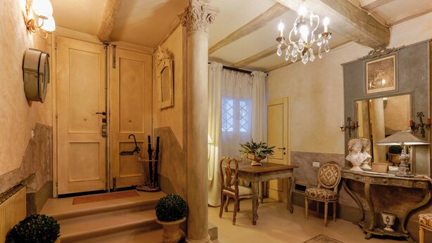 A traditional interior with a staircase, a dining area, and a chandelier. - Gallery Guesthouse (Bologna)