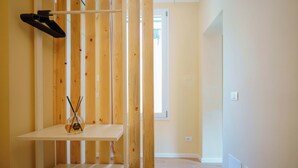 A room with a wooden partition, a white shelf, and a door leading to another room. - Levante Collection (Bologna)