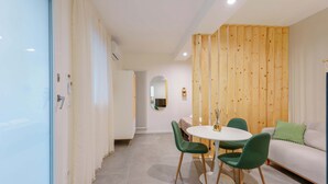 A modern interior with a dining area, a sofa, and a wooden accent wall. - Levante Collection (Bologna)