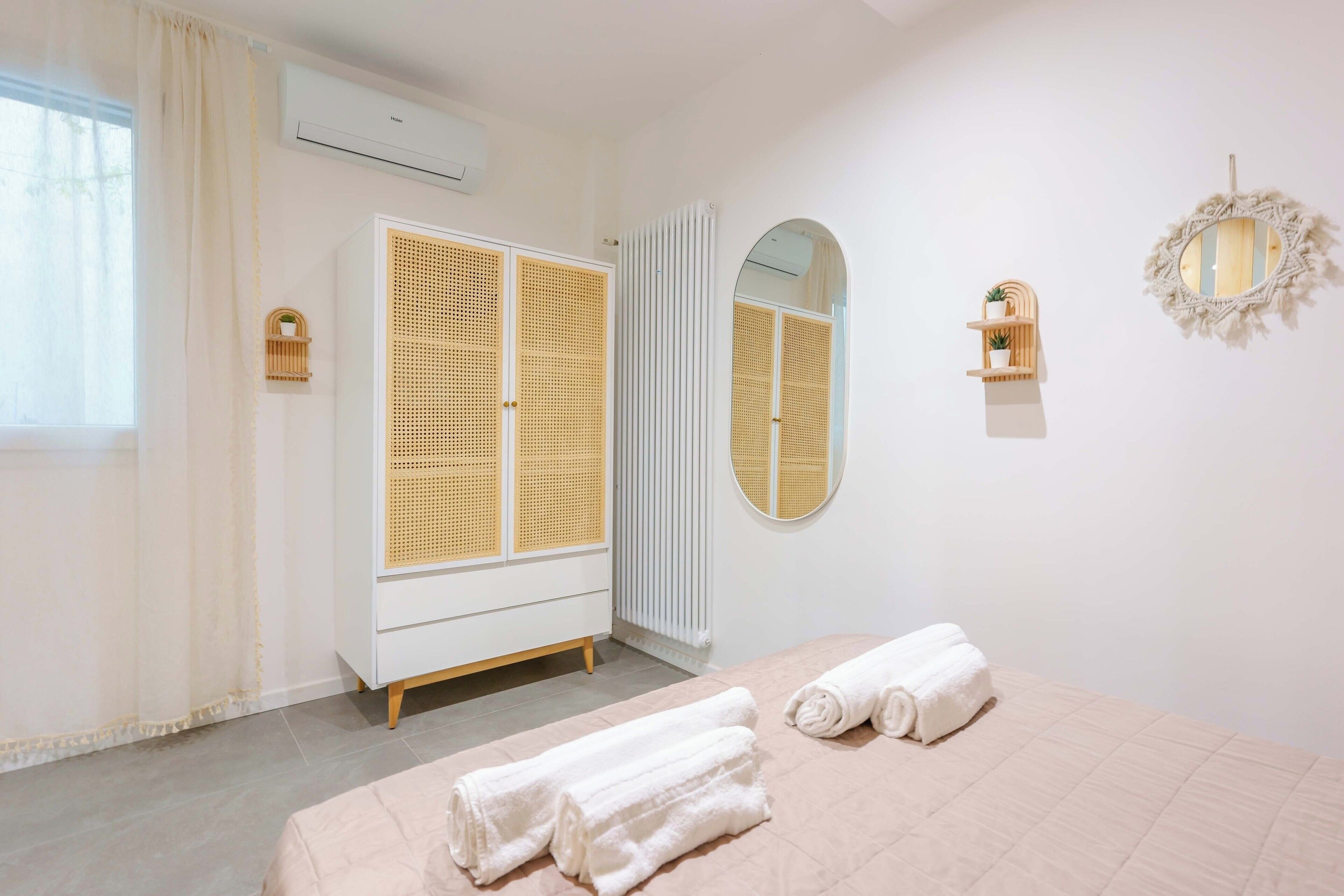 Un dormitorio con cama, armario, espejo y radiador.