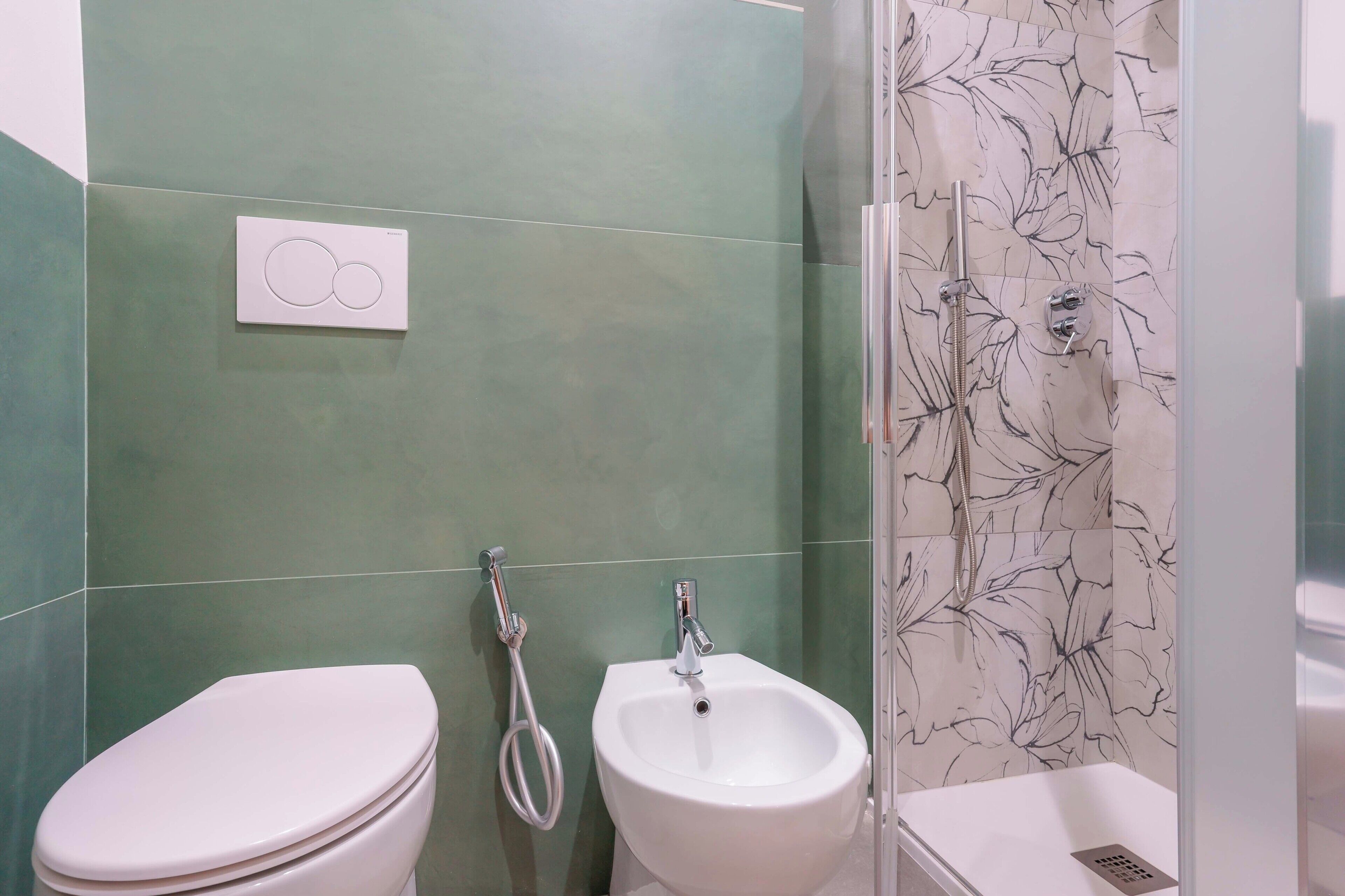 Een badkamer met toilet, hygiëneschuimer en douche.