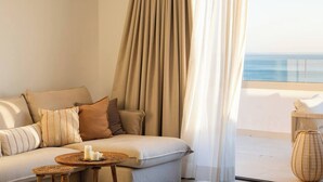 A room with a sofa, a small table with candles, and a view of the sea through sheer curtains. - Panorama Luxury Penthouse in Higueron (Fuengirola)