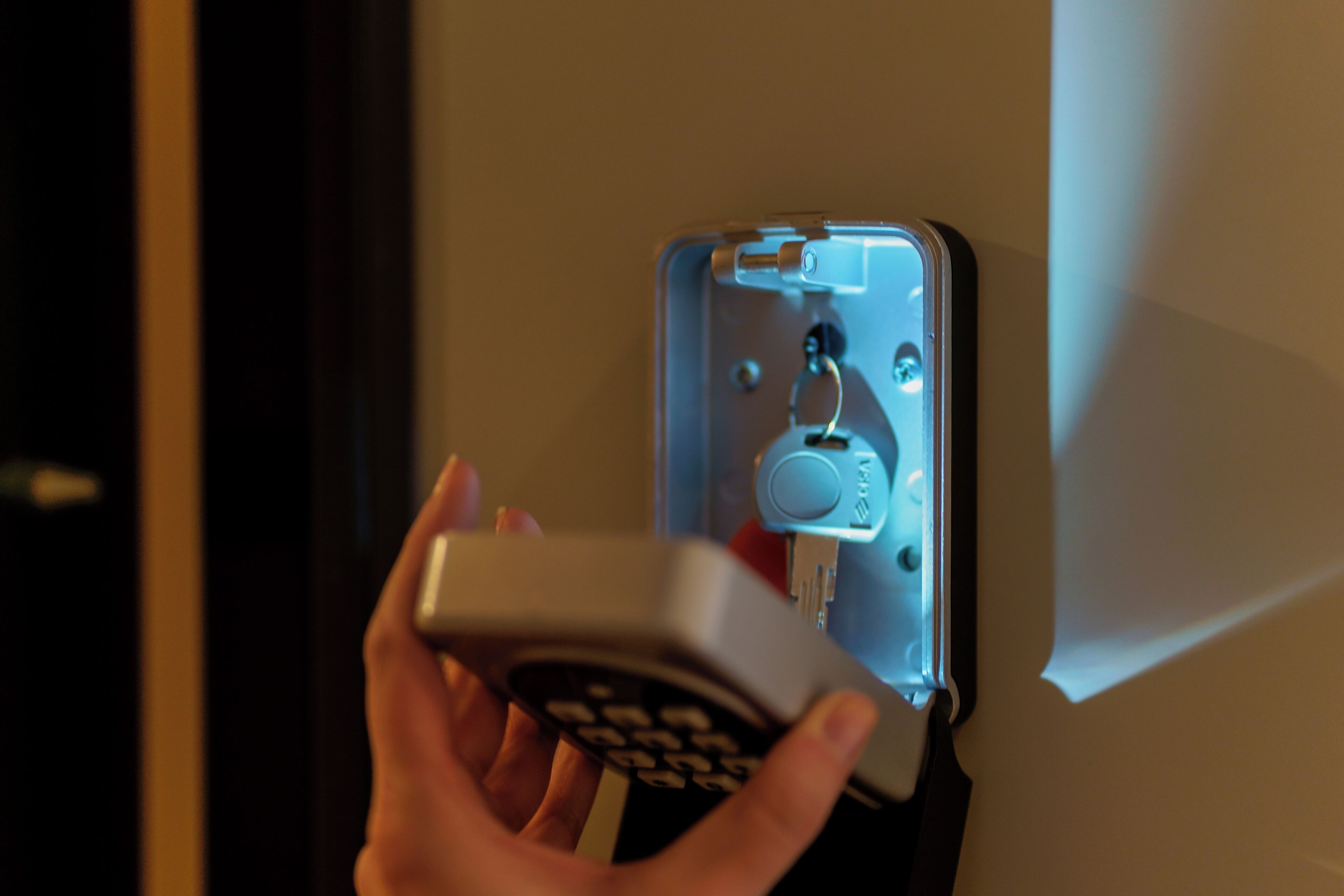 A hand operating a keycard reader, likely for room access.