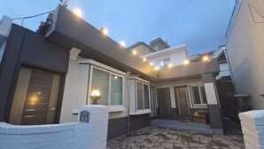 A modern building with a stone-tiled courtyard, large windows, and a visible address sign. - Sokcho Family House Near Seorak Port, Seafood Market & Beach (Walkable) (Sokcho-si)
