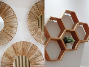A wall with three circular wall decorations and a hexagonal wooden shelf unit with a plant. - Loft raffiné 3 chambres proche Buttes Chaumont (Paris)